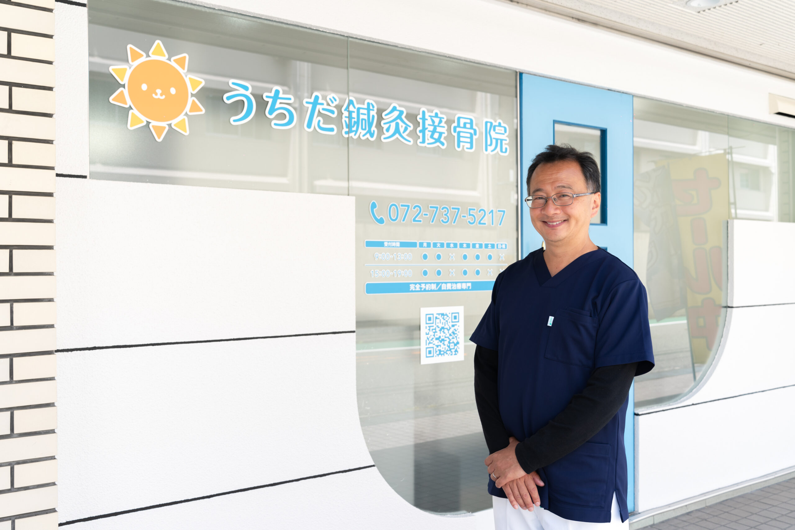 うちだ鍼灸接骨院の前に笑顔で立つ内田院長